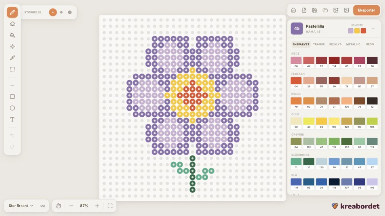 Kreabordet med en lilla perleblomst, tegneværktøjer og Hama-farvepalette